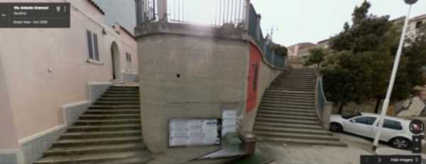 Screen Grab of Google Street View of the wall on Via Antonio Gramsci where the Obama-Berlusconi-Progress-Process Mural is located in Orgosolo. In this screenshot, the wall is bare.