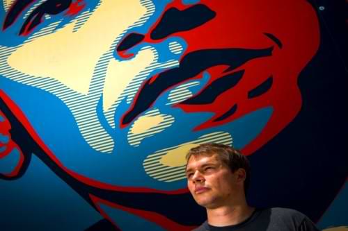 A man standing in front of the Obama Hope image