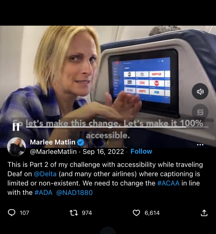 A screenshot of a tweet by Marlee Matlin shows a video of Marlee on a plane, a seatback monitor in front of her. She is signing, “access.” Open subtitles at the bottom read, "So let's make this change. Let's make it 100% accessible." Her tweet reads, "This is Part 2 of my challenge with accessibility while traveling Deaf on @Delta (and many other airlines) where captioning is limited or non-existent. We need to change the #ACAA in line with the #ADA @NAD 1880."