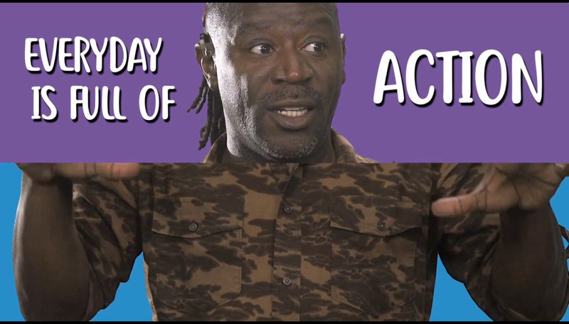 Wawa is shown in two parts of a split screen. The top half shows his face in front of a purple background with white text on the left and right sides of his smiling face as he looks to the left. The text reads, "Everyday is full of action." The bottom half of the screen shows his upper body against a blue background, signing the word "action."