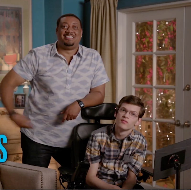 Cedric, standing next to Micah, is speaking. Cedric's arm is pushing the word “Speechless” off screen with only part of the word shown.